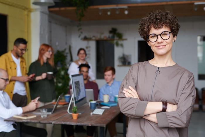 A smiling team member with glasses standing in the office